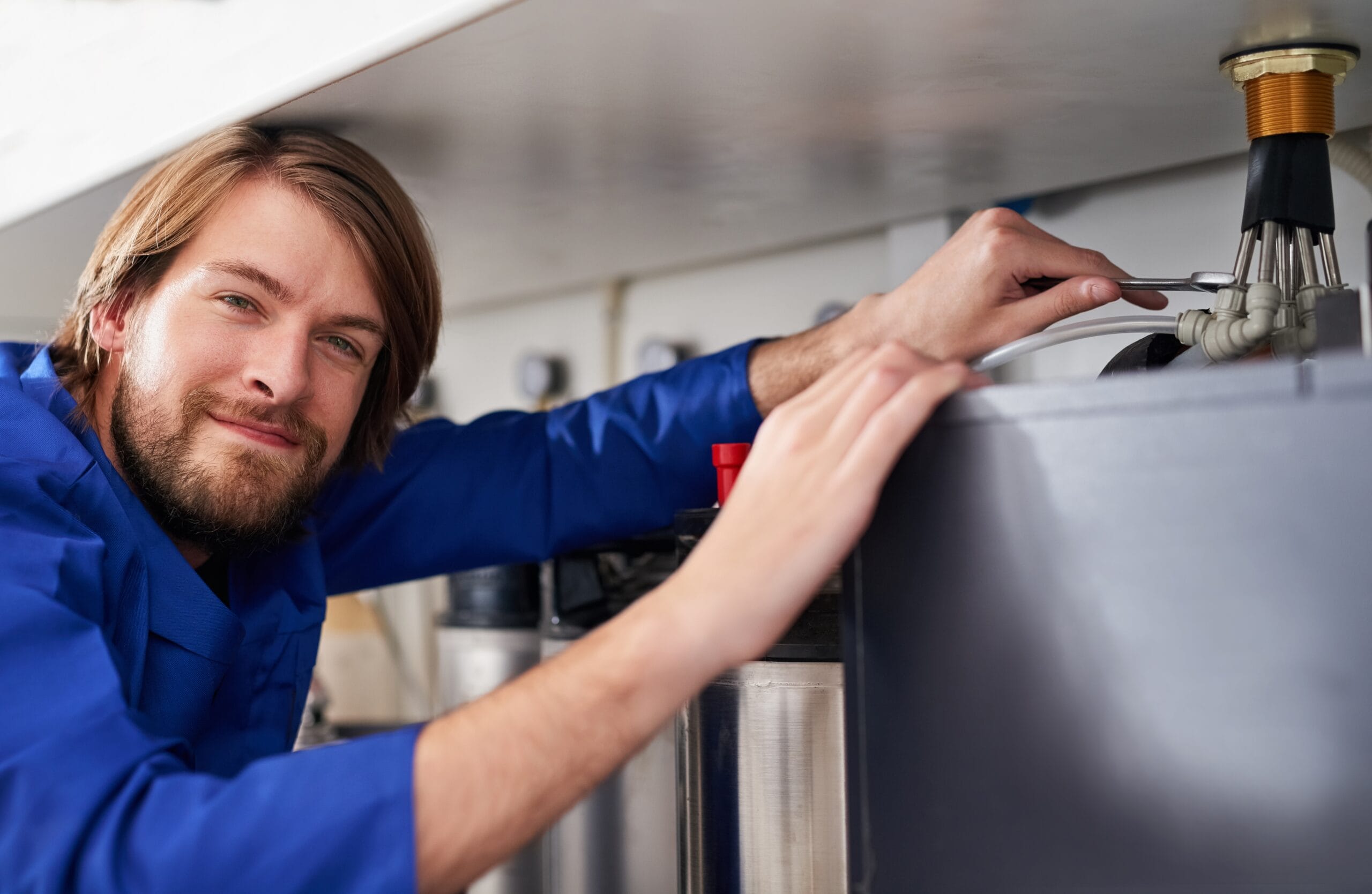Technician servicing a residential water heater tank in Orangevale